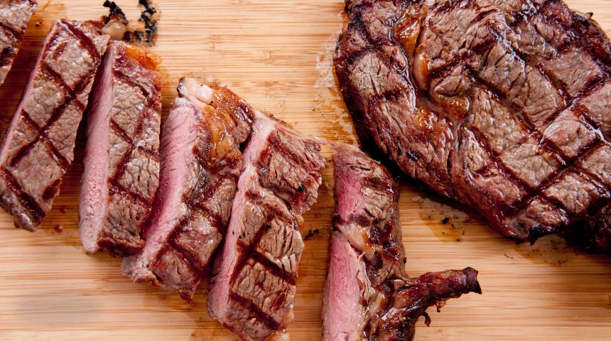 Two cooked steaks on a cutting board.